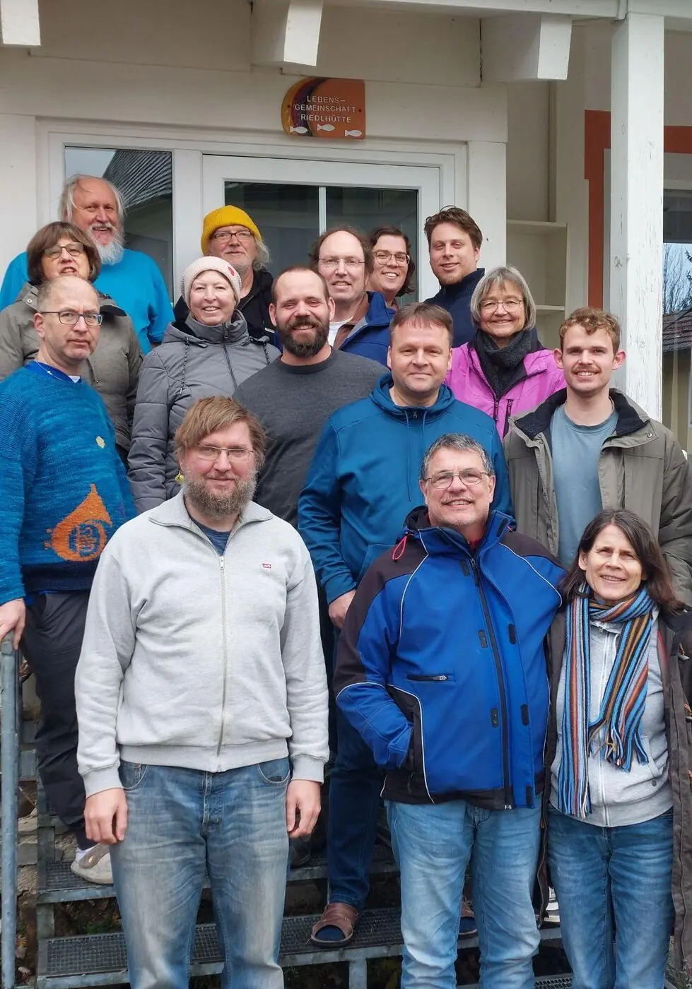 Gruppenfoto: Bewohner und Mitarbeiter der Lebensgemeinschaft auf der Treppe vor dem Haus